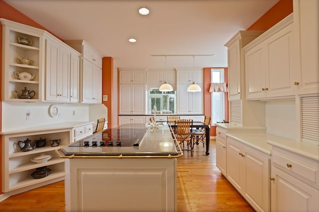 5 Mission Rdg, Frankenmuth, MI 48734 - kitchen with open shelves, black electric cooktop, a center island, white cabinets, and light wood-style flooring