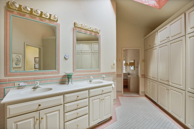5 Mission Rdg, Frankenmuth, MI 48734 - bathroom featuring tile walls, tile patterned flooring, double vanity, lofted ceiling, and a wainscoted wall