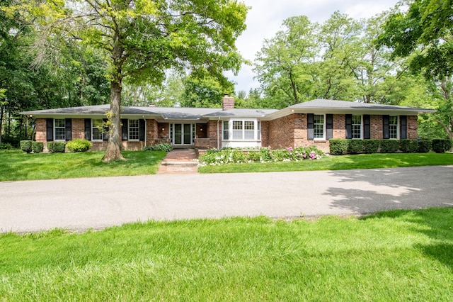 144 Barton N Dr, Ann Arbor, MI 48105 - single story home with brick siding, a chimney, and a front yard