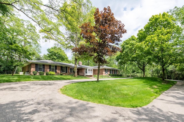 144 Barton N Dr, Ann Arbor, MI 48105 - ranch-style home with curved driveway, brick siding, a front yard, and a chimney