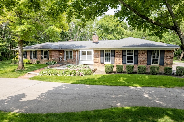 144 Barton N Dr, Ann Arbor, MI 48105 - ranch-style house with brick siding, a chimney, and a front yard