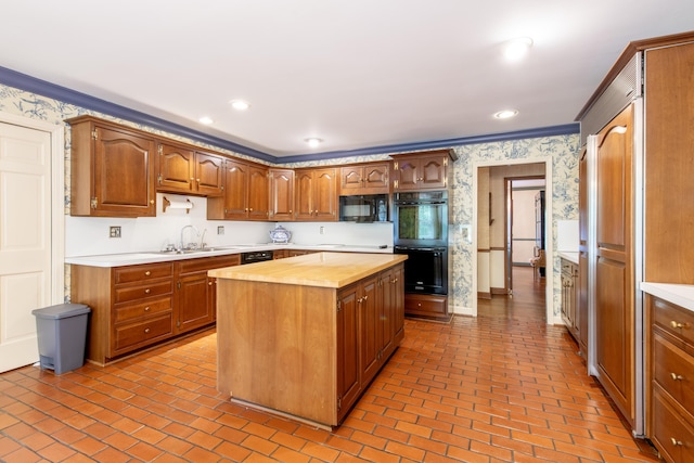 144 Barton N Dr, Ann Arbor, MI 48105 - kitchen featuring black appliances, brick floors, wallpapered walls, butcher block counters, and a kitchen island