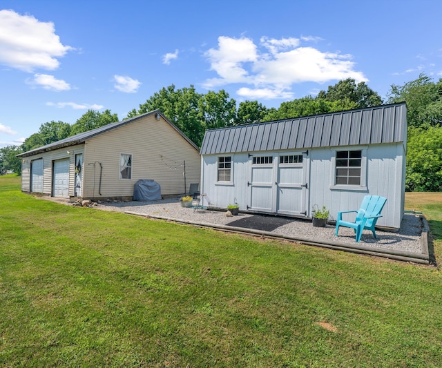 278 E Southern Rd, Coldwater, MI 49036 - back of property with a lawn, a detached garage, board and batten siding, and a metal roof