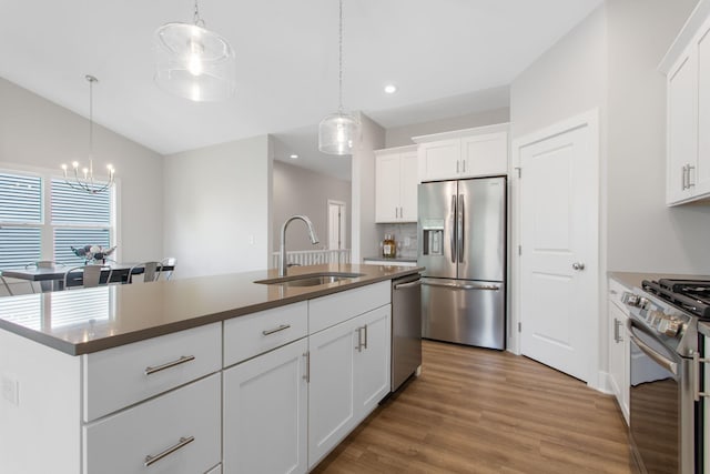 1519 Eagle Shore Ct, Hudsonville, MI 49426 - kitchen with appliances with stainless steel finishes, a chandelier, light wood-style floors, recessed lighting, and decorative light fixtures