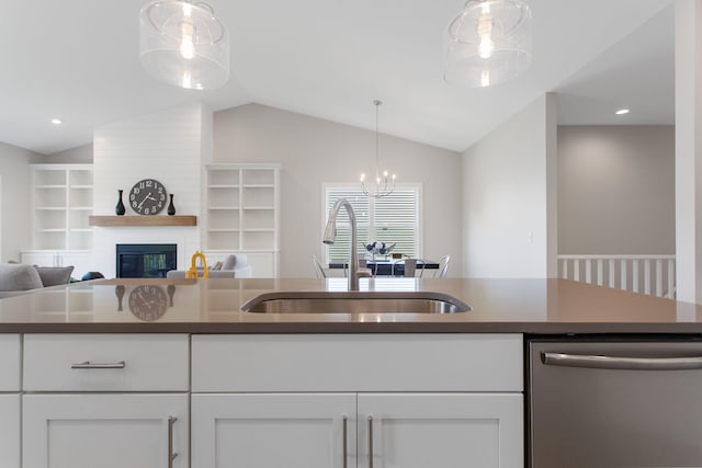 1519 Eagle Shore Ct, Hudsonville, MI 49426 - kitchen with stainless steel dishwasher, lofted ceiling, white cabinetry, dark countertops, and a large fireplace