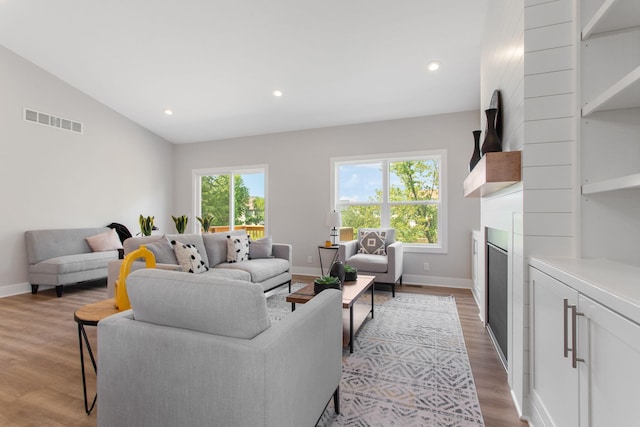 1519 Eagle Shore Ct, Hudsonville, MI 49426 - living area with healthy amount of natural light, a fireplace, lofted ceiling, wood finished floors, and recessed lighting