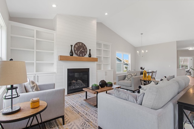 1519 Eagle Shore Ct, Hudsonville, MI 49426 - living area with built in features, vaulted ceiling, a chandelier, a fireplace, and light wood-style floors