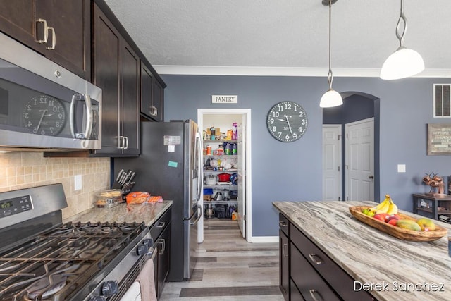 5845 Nile Dr SW, Wyoming, MI 49418 - kitchen featuring stainless steel appliances, light wood-type flooring, arched walkways, decorative backsplash, and light stone counters