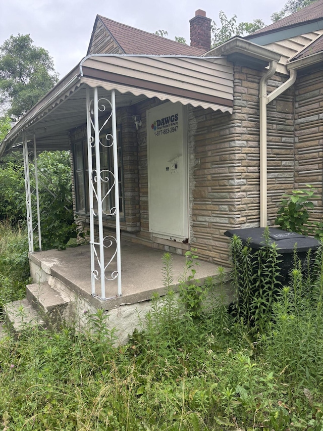 20026 Avon Ave, Detroit, MI 48219 - doorway to property with stone siding and a chimney