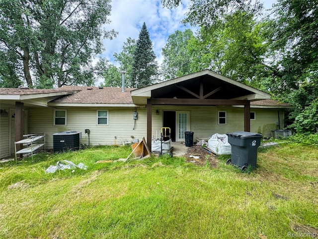 7889 Chilson Rd, Hamburg, MI 48169 - rear view of house with a shingled roof and a lawn
