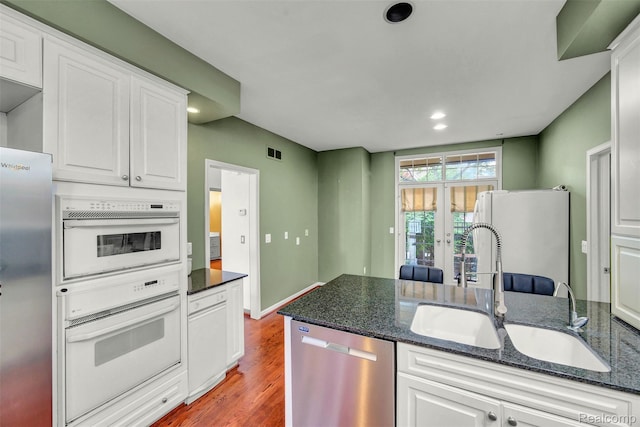 584 Cambridge Way, Bloomfield Hills, MI 48304 - kitchen featuring appliances with stainless steel finishes, white cabinetry, light wood-type flooring, recessed lighting, and dark stone countertops