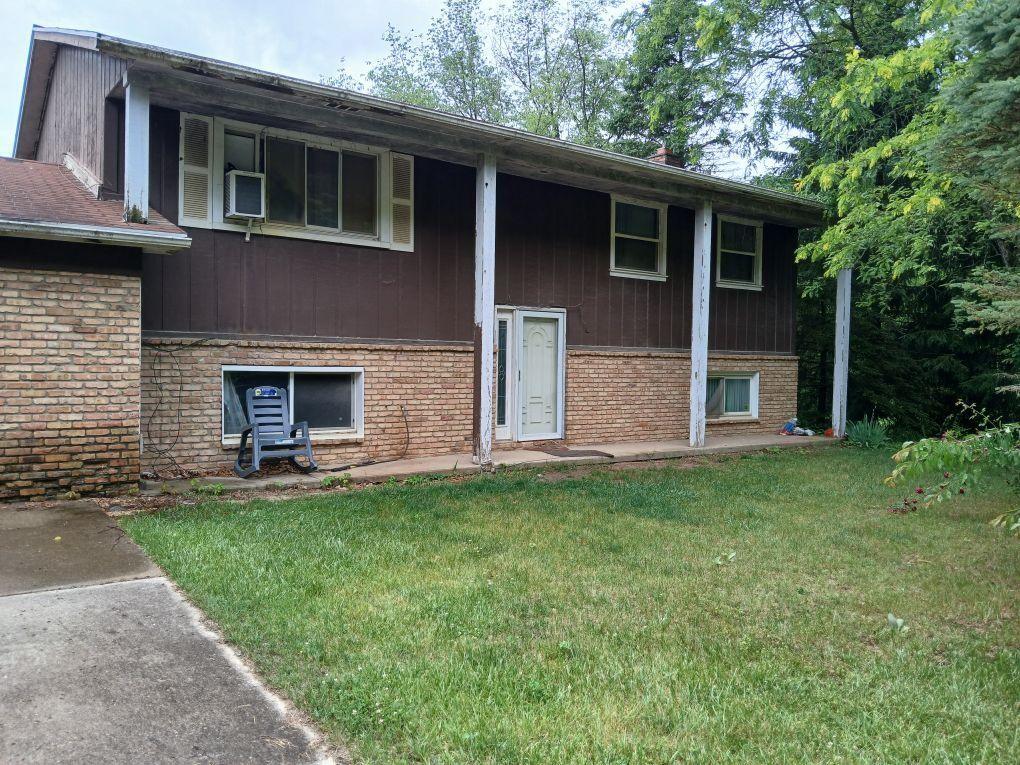 5490 Pingree Rd, Howell, MI 48843 - view of front facade featuring brick siding and a front yard
