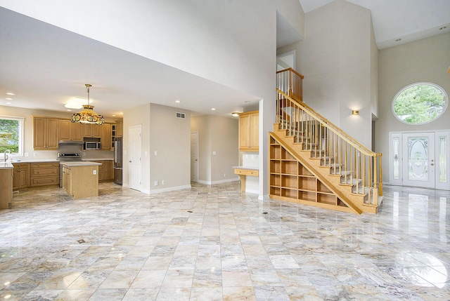 436 Pine Brae St, Ann Arbor, MI 48105 - unfurnished living room featuring stairs, a towering ceiling, and recessed lighting