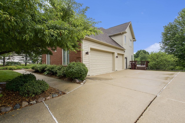 436 Pine Brae St, Ann Arbor, MI 48105 - view of home's exterior with driveway, a garage, a shingled roof, and brick siding