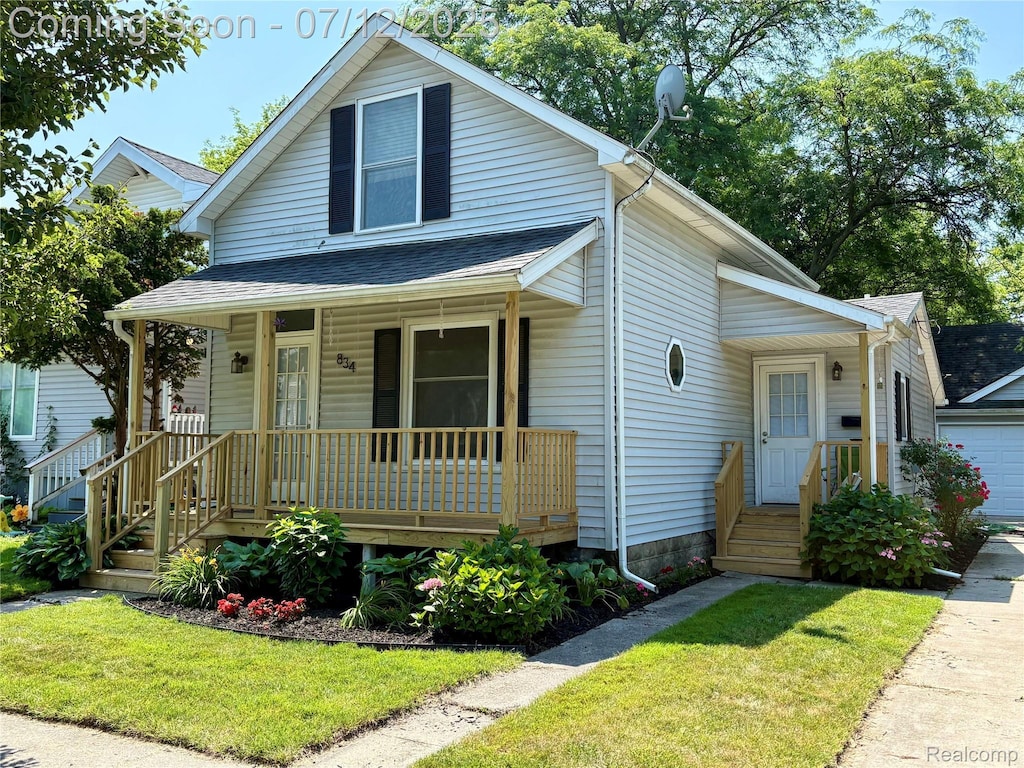 834 Union St, Port Huron, MI 48060 - bungalow-style home with a porch, a garage, a front yard, and roof with shingles