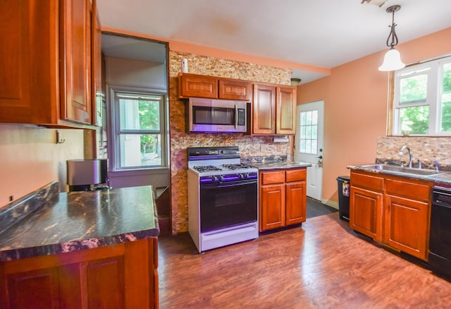 500 W Chicago St, Coldwater, MI 49036 - kitchen with white range with gas stovetop, stainless steel microwave, backsplash, and dark wood-style floors