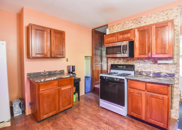500 W Chicago St, Coldwater, MI 49036 - kitchen featuring range with gas stovetop, stainless steel microwave, dark countertops, dark wood-style floors, and brown cabinets