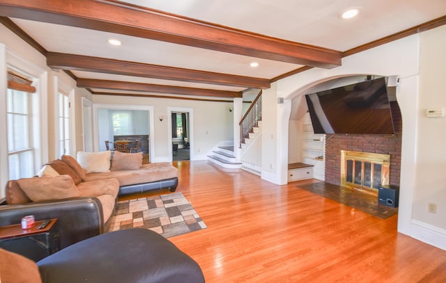 500 W Chicago St, Coldwater, MI 49036 - living room with a brick fireplace, beam ceiling, wood finished floors, ornamental molding, and stairway