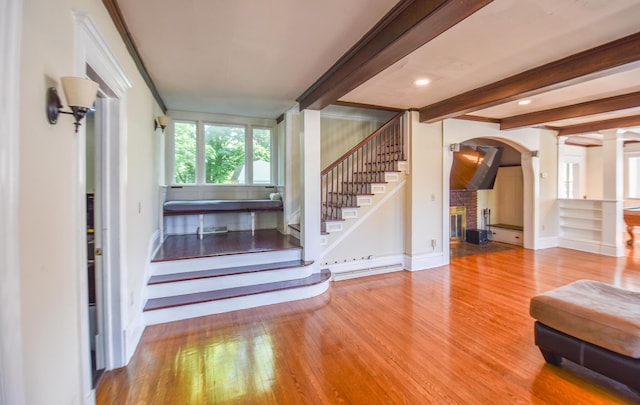 500 W Chicago St, Coldwater, MI 49036 - stairs with wood finished floors, a brick fireplace, arched walkways, decorative columns, and beamed ceiling