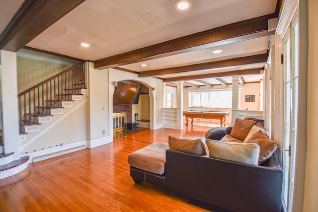 500 W Chicago St, Coldwater, MI 49036 - living area featuring arched walkways, wood finished floors, stairway, a brick fireplace, and beamed ceiling