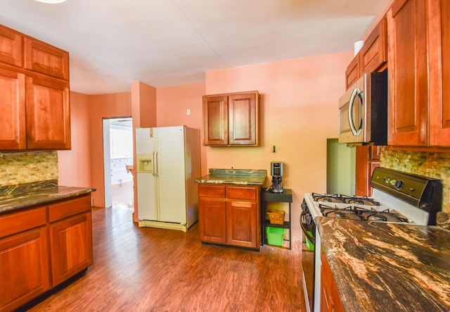 500 W Chicago St, Coldwater, MI 49036 - kitchen featuring range with gas stovetop, stainless steel microwave, white refrigerator with ice dispenser, and backsplash