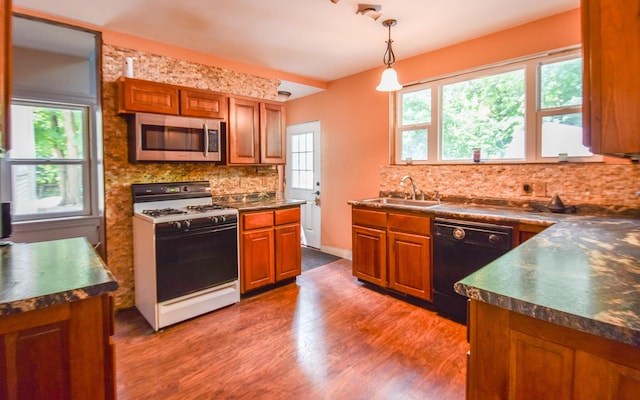 500 W Chicago St, Coldwater, MI 49036 - kitchen with stainless steel microwave, white range with gas cooktop, dishwasher, dark countertops, and brown cabinetry