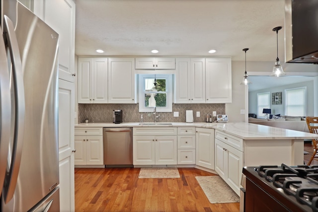 516 Zehnder Dr, Frankenmuth, MI 48734 - kitchen featuring appliances with stainless steel finishes, a peninsula, white cabinetry, light wood-style floors, and recessed lighting