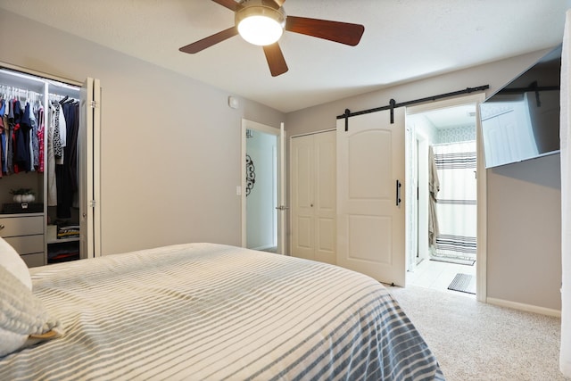 516 Zehnder Dr, Frankenmuth, MI 48734 - carpeted bedroom featuring a closet, ensuite bathroom, a ceiling fan, and a barn door