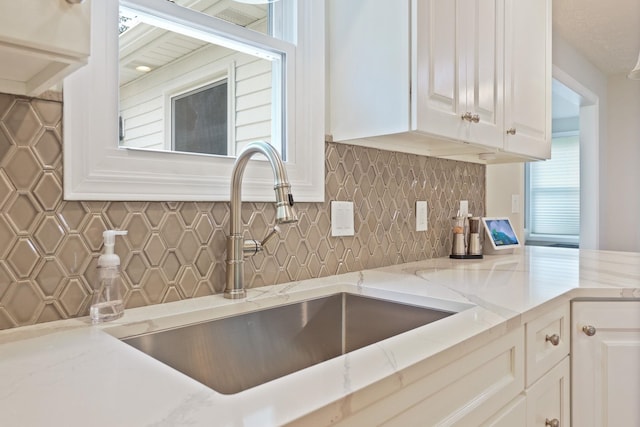 516 Zehnder Dr, Frankenmuth, MI 48734 - kitchen featuring white cabinetry, tasteful backsplash, and light stone countertops