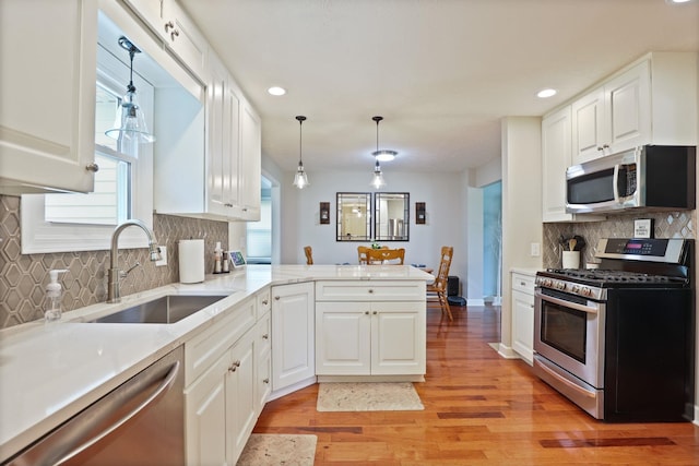 516 Zehnder Dr, Frankenmuth, MI 48734 - kitchen featuring stainless steel appliances, light wood-style flooring, white cabinets, recessed lighting, and tasteful backsplash