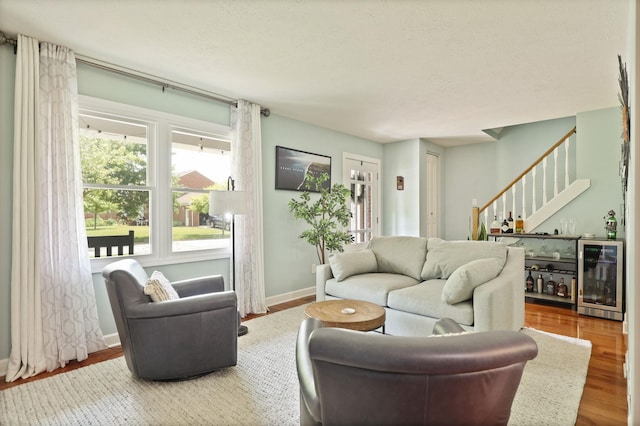 516 Zehnder Dr, Frankenmuth, MI 48734 - living area featuring beverage cooler, stairway, wood finished floors, and a bar