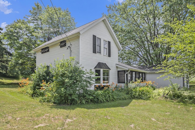 7035 W Filmore Rd, Mears, MI 49436 - view of home's exterior with a lawn and a sunroom