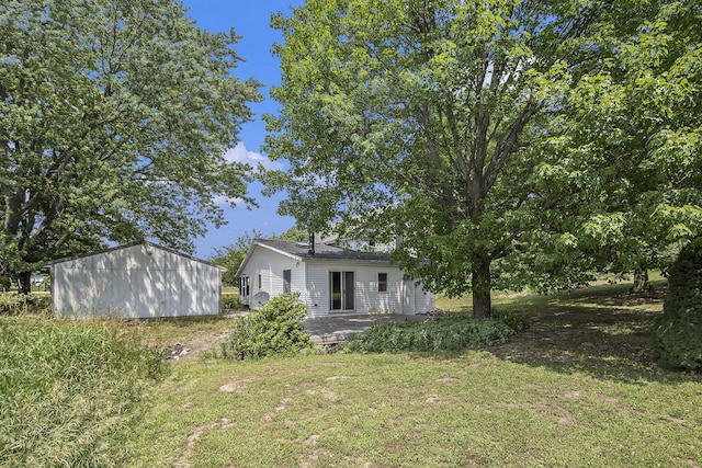 7035 W Filmore Rd, Mears, MI 49436 - view of green lawn with a patio area and an outdoor structure