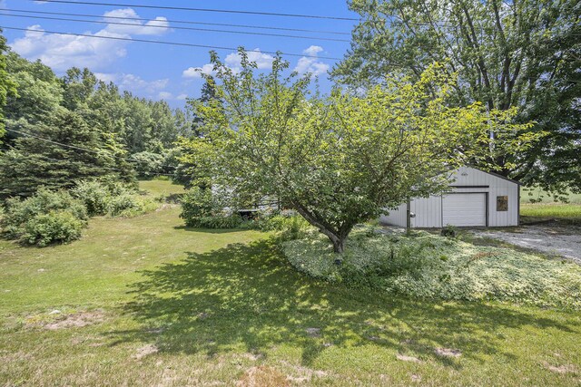 7035 W Filmore Rd, Mears, MI 49436 - view of grassy yard featuring an outbuilding and a detached garage