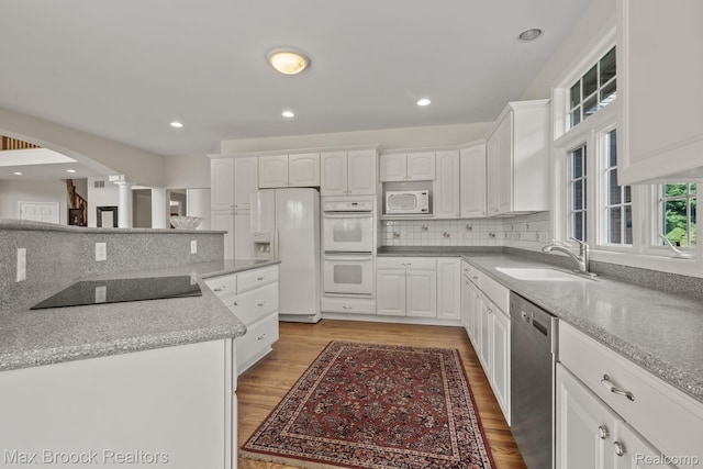 519 Hawksmoore Dr, Clarkston, MI 48348 - kitchen with white appliances, ornate columns, white cabinets, backsplash, and recessed lighting
