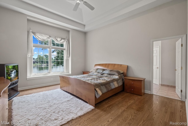 519 Hawksmoore Dr, Clarkston, MI 48348 - bedroom with wood finished floors, a ceiling fan, and a tray ceiling