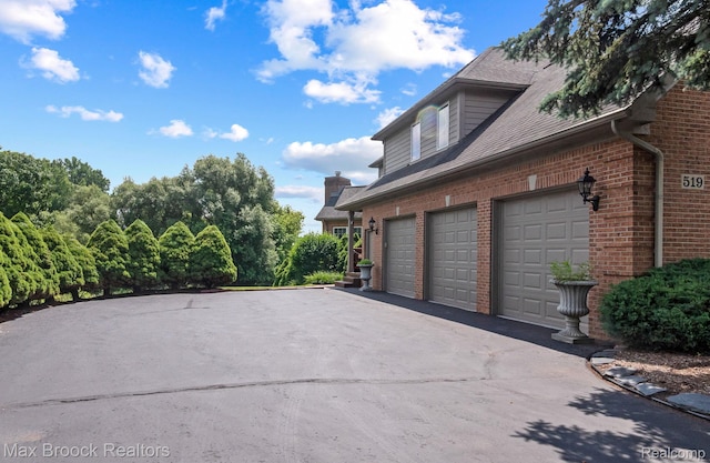 519 Hawksmoore Dr, Clarkston, MI 48348 - view of side of home with brick siding, a shingled roof, and driveway