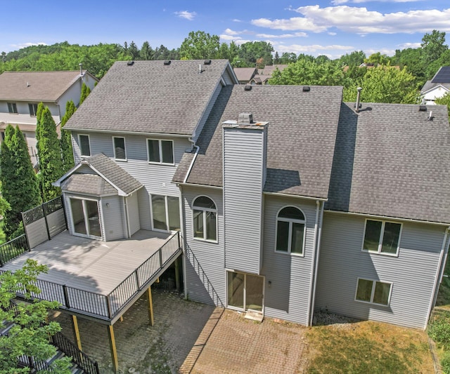 2418 Meadowridge Ct, Ann Arbor, MI 48105 - rear view of house with a chimney, a deck, roof with shingles, and a residential view