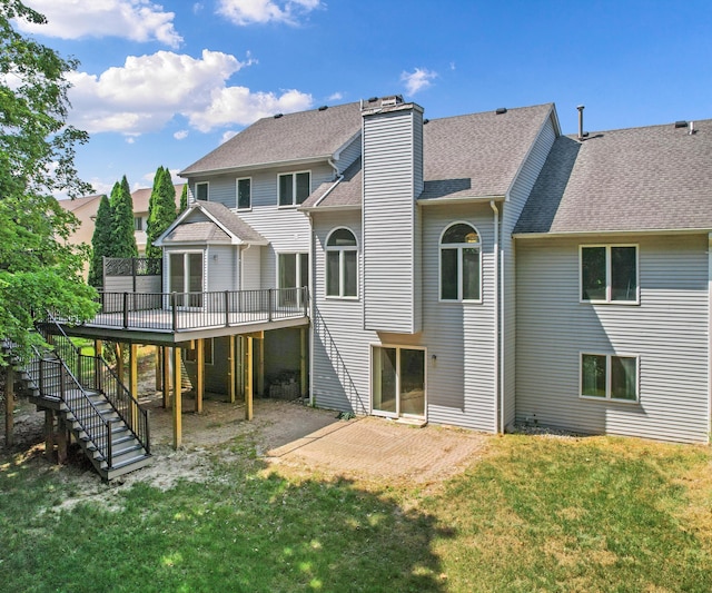 2418 Meadowridge Ct, Ann Arbor, MI 48105 - back of property with stairway, a wooden deck, a lawn, roof with shingles, and a patio area