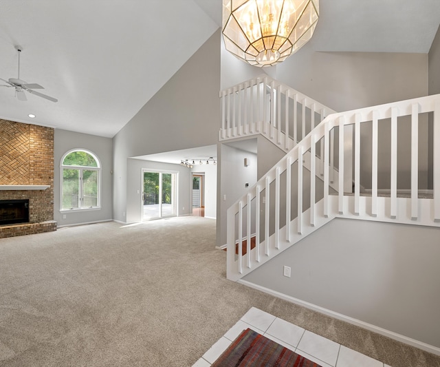 2418 Meadowridge Ct, Ann Arbor, MI 48105 - stairs featuring a chandelier, carpet floors, high vaulted ceiling, ceiling fan, and a brick fireplace