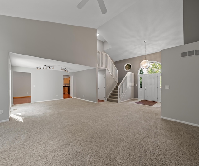 2418 Meadowridge Ct, Ann Arbor, MI 48105 - unfurnished living room with carpet floors, stairs, a ceiling fan, and high vaulted ceiling