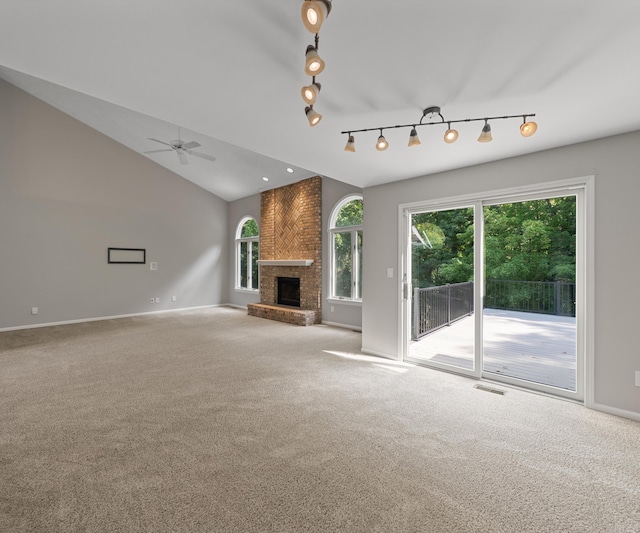 2418 Meadowridge Ct, Ann Arbor, MI 48105 - unfurnished living room with carpet floors, track lighting, a ceiling fan, a brick fireplace, and healthy amount of natural light