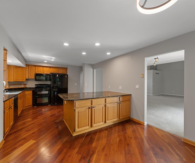 2418 Meadowridge Ct, Ann Arbor, MI 48105 - kitchen with black appliances, dark countertops, a peninsula, recessed lighting, and dark wood-style flooring