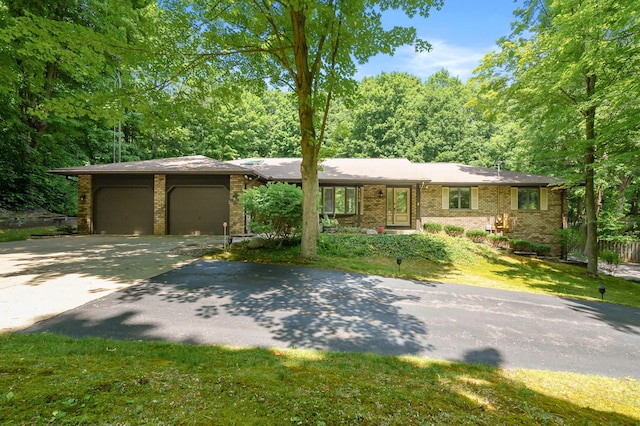 1130 W G Ave, Kalamazoo, MI 49009 - view of front of home featuring asphalt driveway, brick siding, a garage, and a front lawn