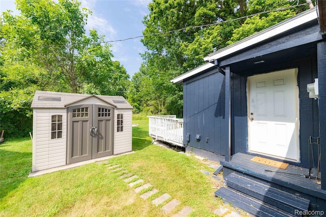 8614 Lake Rd, Grosse Ile, MI 48138 - view of grassy yard featuring a shed, a wooden deck, and view of wooded area