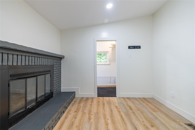8614 Lake Rd, Grosse Ile, MI 48138 - unfurnished living room with wood finished floors, a brick fireplace, vaulted ceiling, and recessed lighting