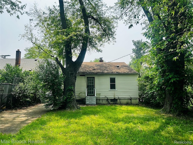 22510 Frisbee St, Detroit, MI 48219 - rear view of house featuring entry steps, a yard, and a chimney