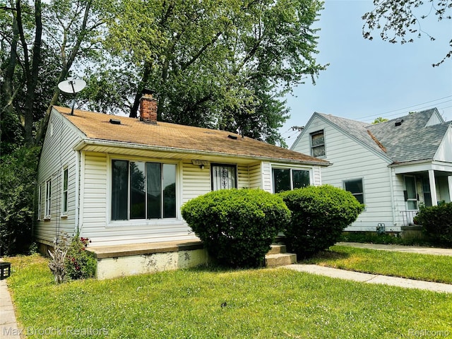 22510 Frisbee St, Detroit, MI 48219 - view of front facade with a chimney and a front lawn