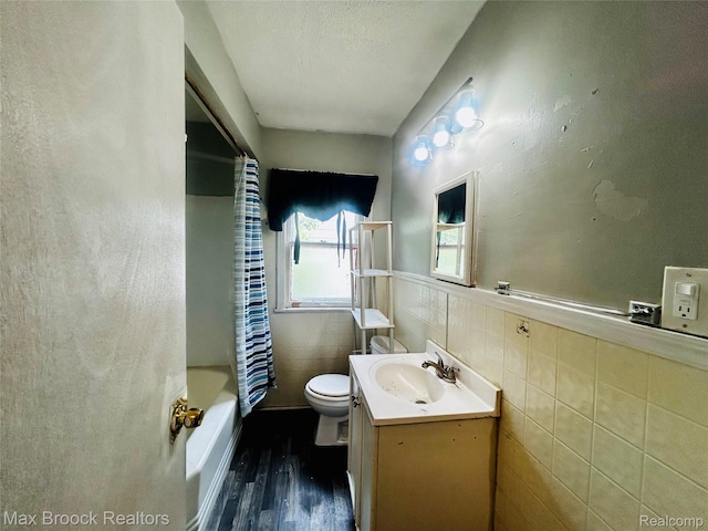 22510 Frisbee St, Detroit, MI 48219 - full bathroom with wood finished floors, vanity, tile walls, shower / bath combination with curtain, and a wainscoted wall