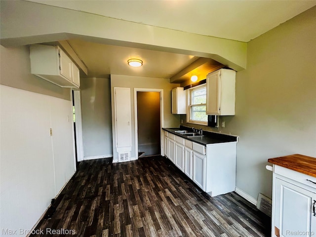 22510 Frisbee St, Detroit, MI 48219 - kitchen featuring dark countertops, dark wood finished floors, and white cabinets